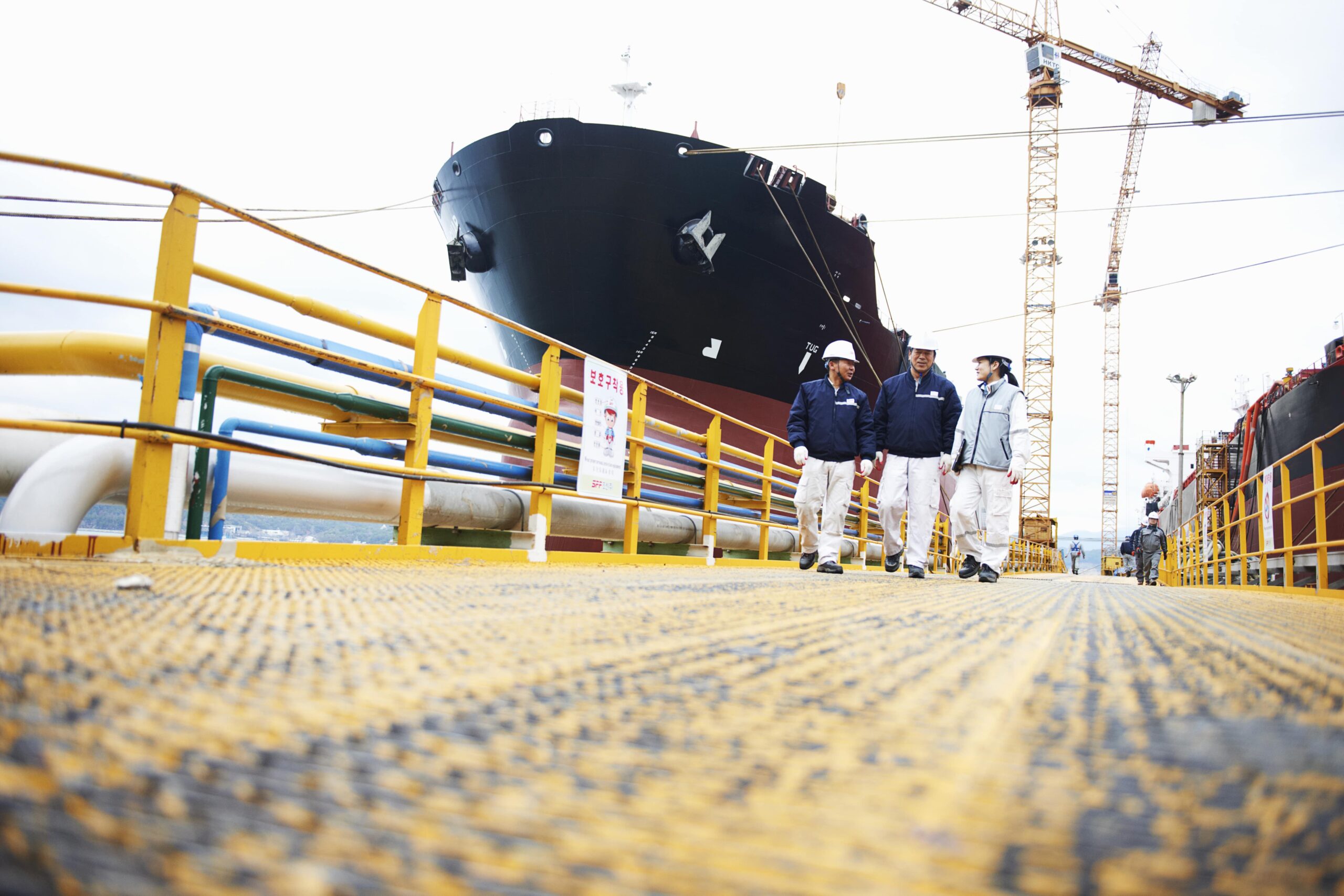 three-workers-at-shipping-port-low-angle-view-go-2024-11-03-01-32-32-utc-min